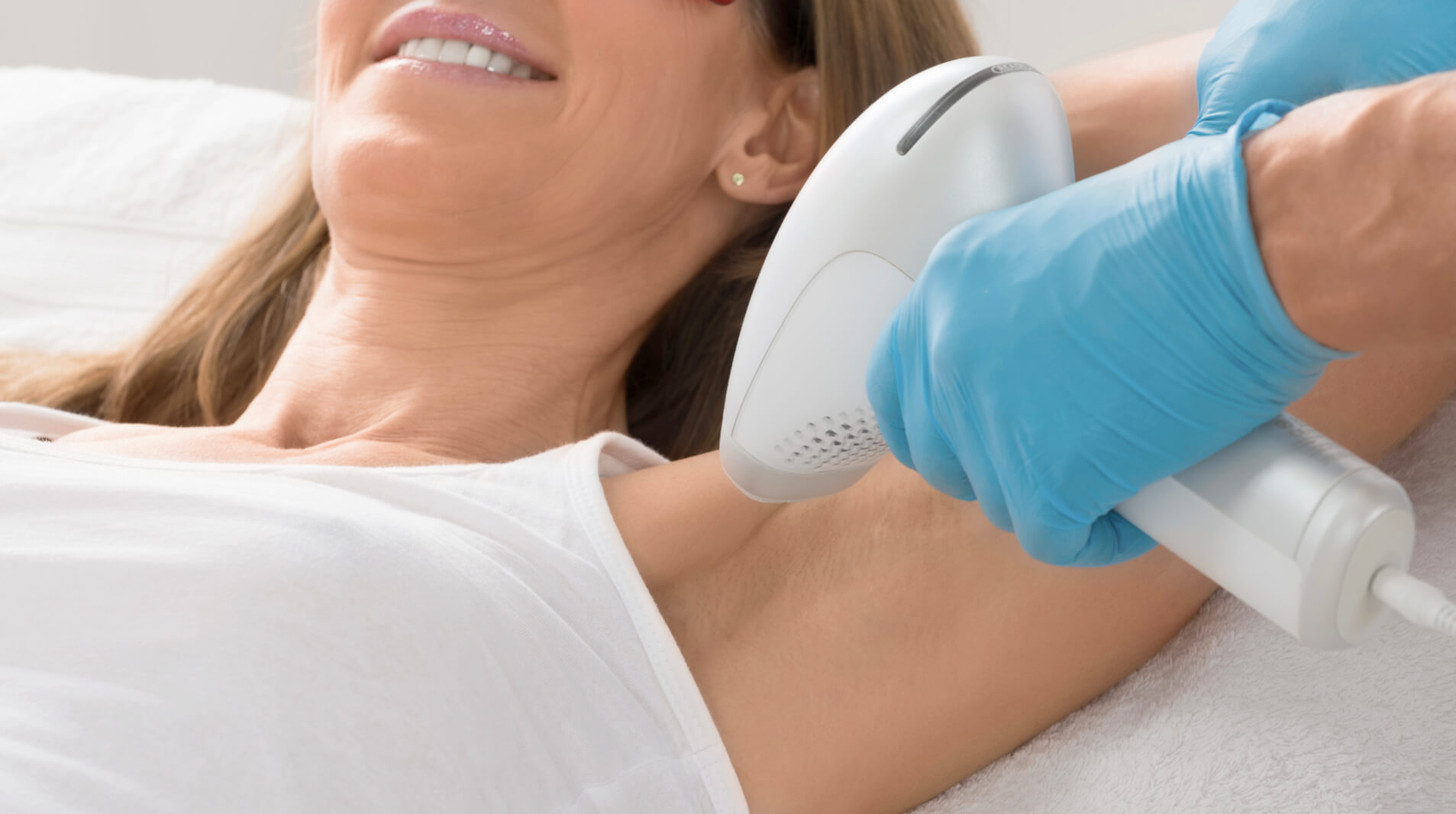 Hier auf dem Bild sieht man wie eine Frau sich die Achseln Lasern lässt. Sie hat sich bereits über die Dauerhafte Haarentfernung Kosten informieren lassen und genießt nun bald haarfreie Achseln.