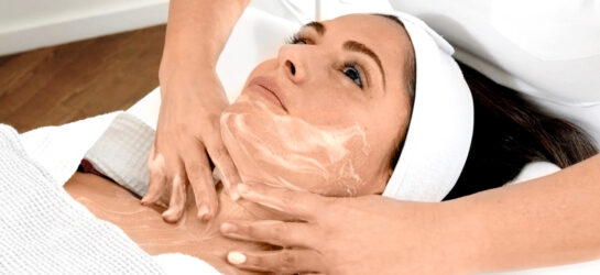 Das erste Bild zeigt eine Frau, die eine sanfte Gesichtsbehandlung erhält. Ein professionelles Peeling Wien wird mit kreisenden Bewegungen auf Gesicht und Hals einmassiert. Diese Art entfernt abgestorbene Hautzellen, regt die Durchblutung an und sorgt für ein frisches, glattes Hautbild. Ideal zur Vorbereitung auf weitere kosmetische Behandlungen.